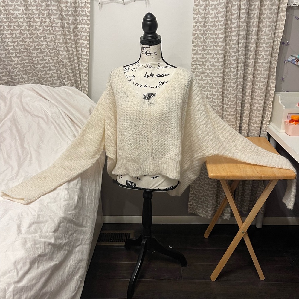 Cream batwing sweater.  Hits at waist.